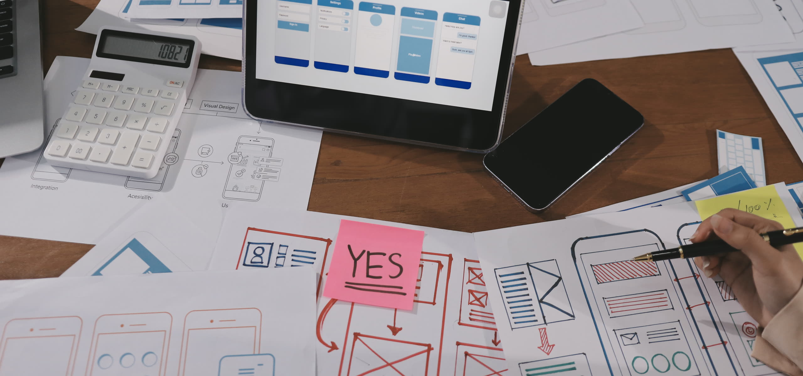 A printed site map marked up in pen beside a laptop showing a page template and a list of old URLs with their redirects.