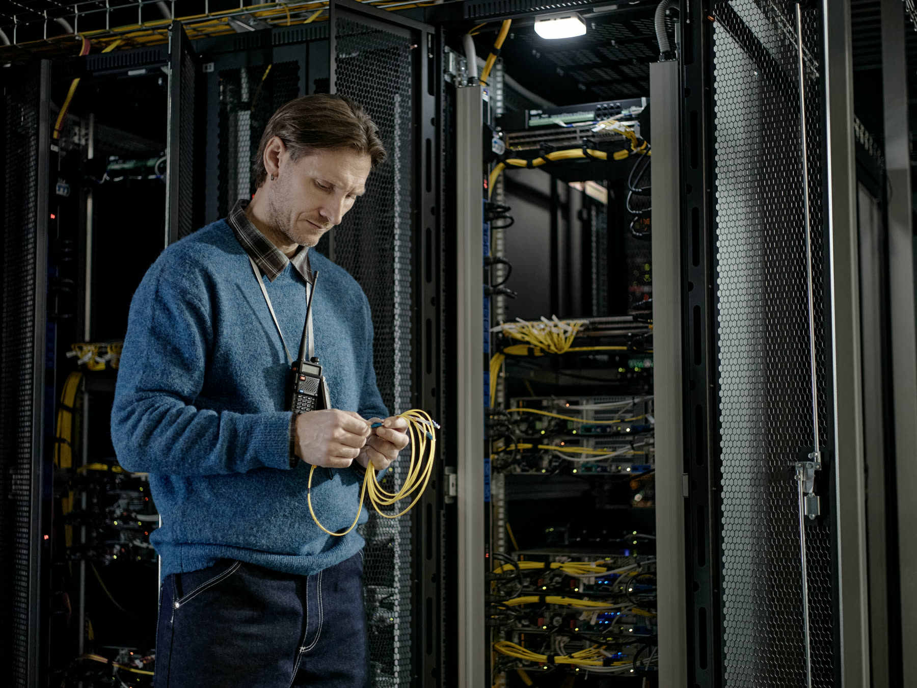 An engineer working at a communications cabinet