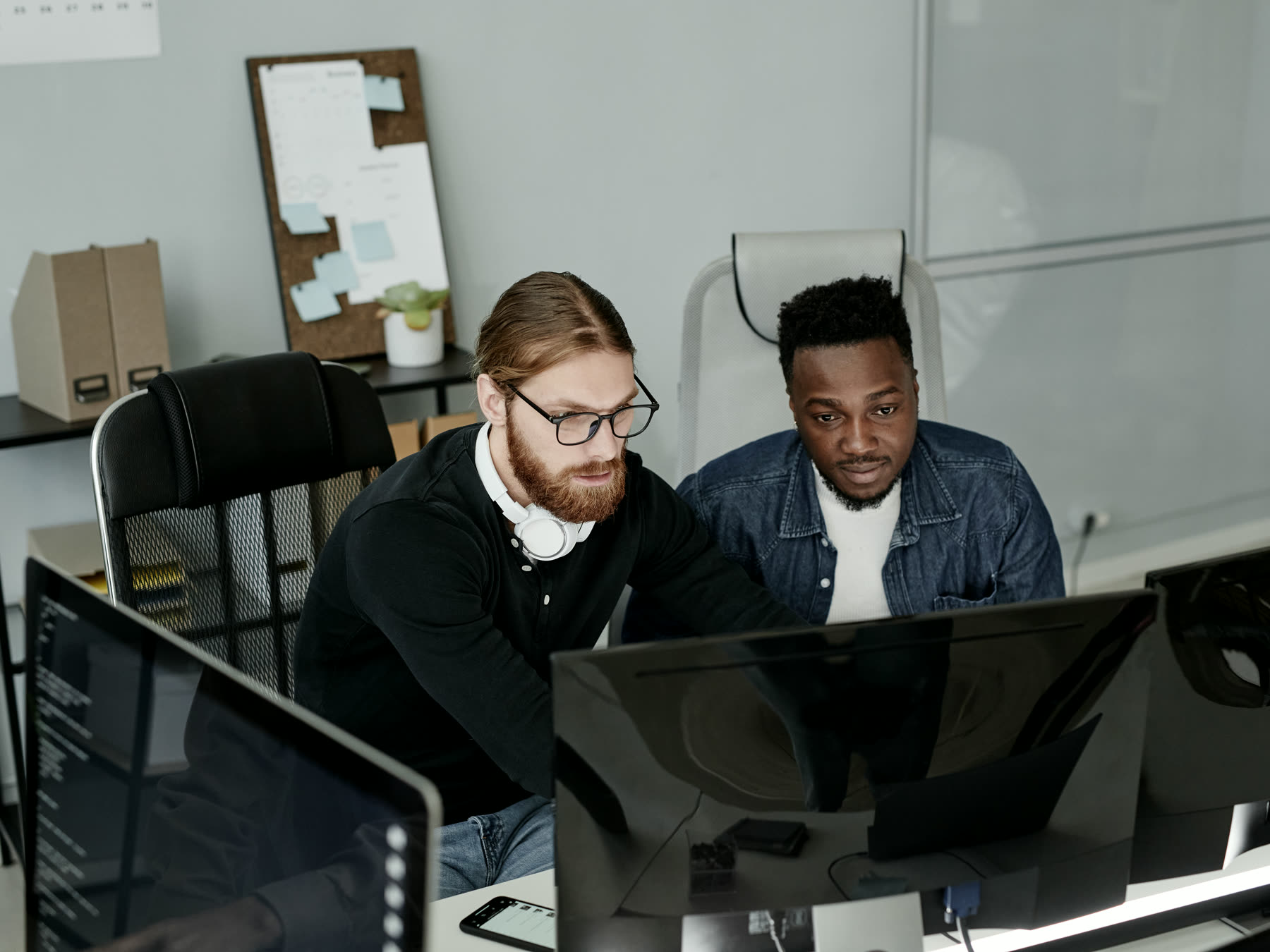 Two developers reviewing an application on screen together